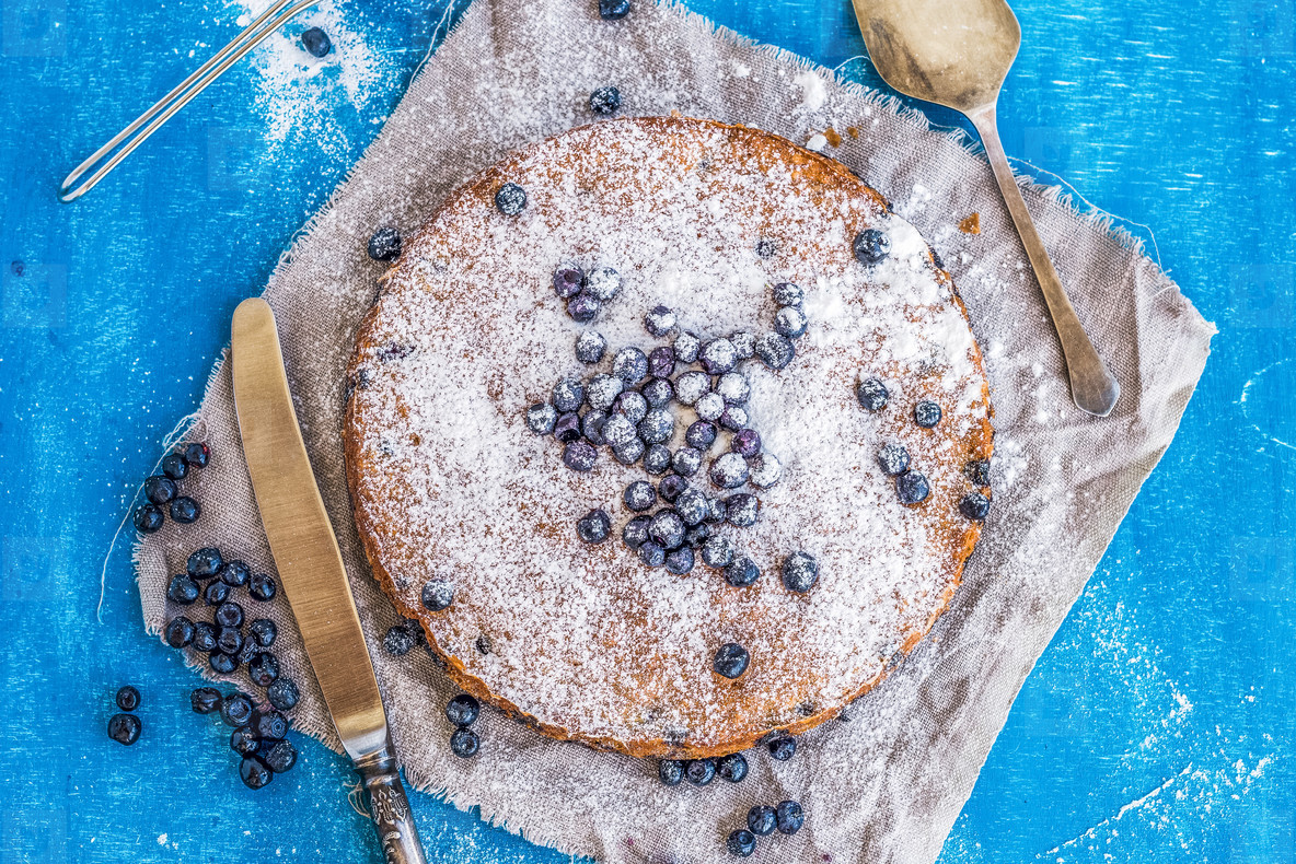 Blueberry cake with fresh bluberries  sugar powder  a knife and