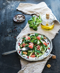 Spring salad with lamb s lettuce  grapefruit  garnet  walnuts and olive oil in vintage metal plate