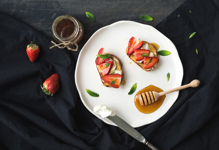 French toasts with strawberry  cream cheese  honey and mint on light ceramic plate