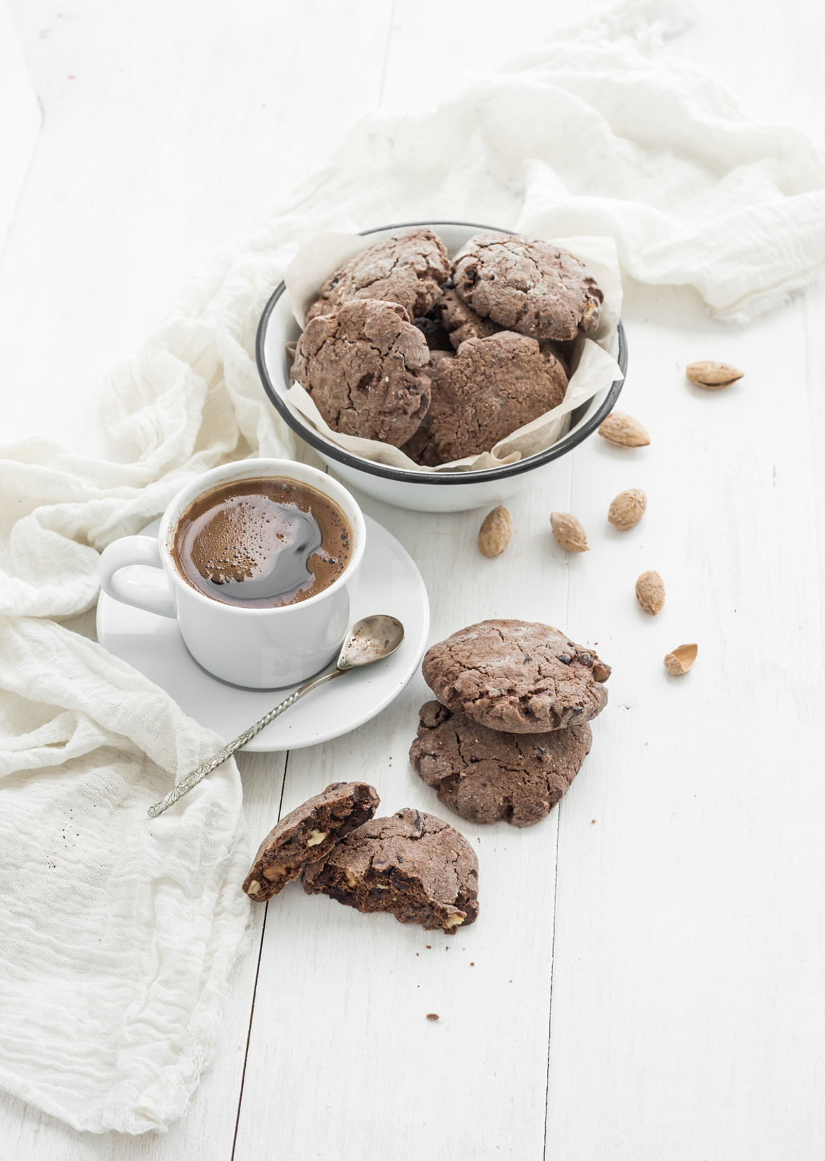 Chocolate cookies with almond and cranberries  cup of coffee  white wooden backdrop