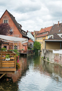 Colorful traditional french houses and a small restaurant terrace on the side of chanel Petite Venise  Colmar  France