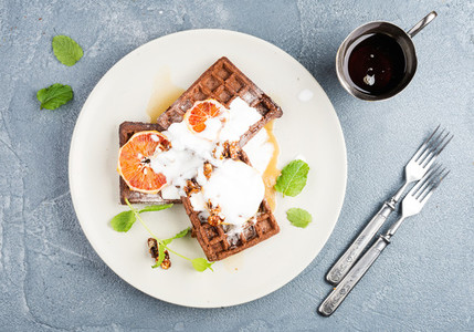 Belgian soft waffles with blood orange  cream  marple syrup and mint  on white plates