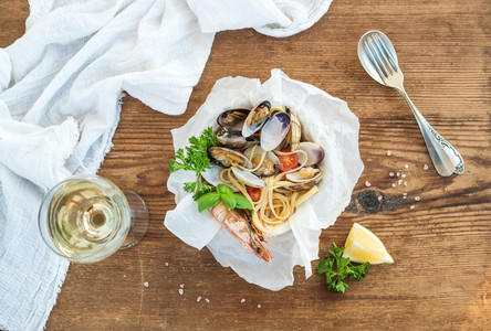 Seafood pasta Spaghetti with clams and shrimps in bowl glass of white wine