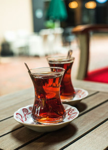 Turkish tea in traditional tulip glasses on table of street cafe