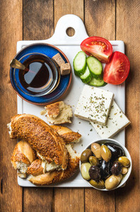 Turkish traditional breakfast with feta cheese  vegetables  olives  simit bagel and tea