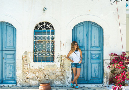 Young blond woman at typical greek traditional town with colorful buildings on Kastelorizo Island  Greece