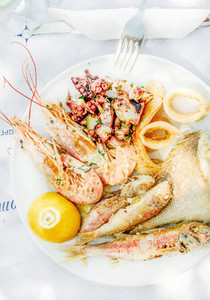 Cooked seafood on plate with lemon and wine