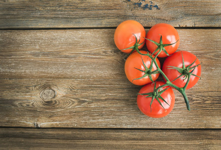 Bunch of fresh ripe red tomatoes over a rustic wood background w