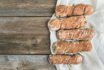 Freshly baked rustic  village bread baguettes set on rough woo