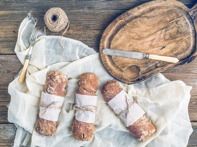 Freshly baked rustic village bread baguettes wrapped in paper