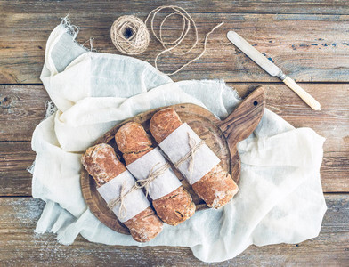 Freshly baked rustic village bread baguettes wrapped in paper