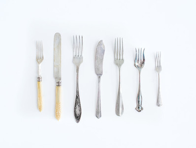 A set of vintage dining knifes and forks of different shapes and