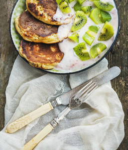 Rustic breakfast set with pancakes with strawberry yogurt and fr