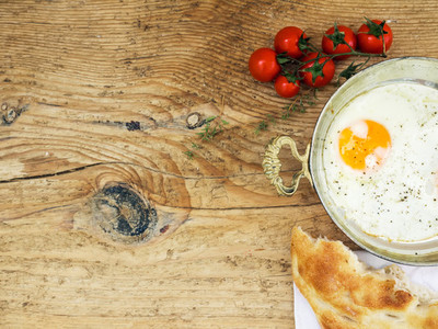 Breakfast set fried egg  bread and cherry tomatoes on a wooden