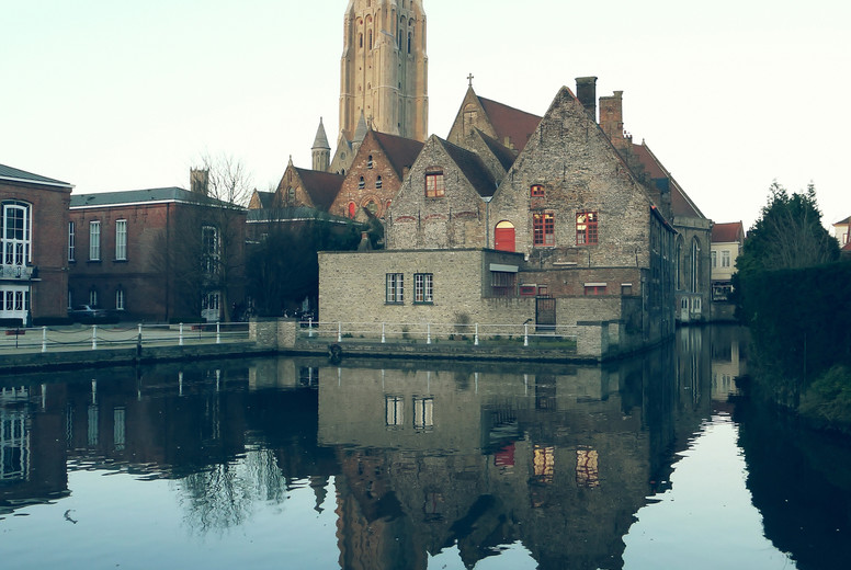 View of cathedral the center Bruges, Belgium, and it's reflection in water.