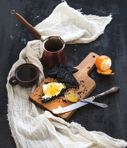 Breakfast set  Black bread toasts with tangerine marmelade and mascarpone cheese  fresh coffee on dark grunge backdrop