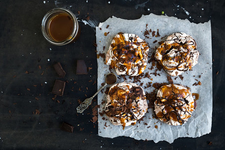 Salted caramel and chocolate meringues over dark grunge surface top view