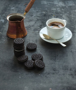 Chocolate cookies with cup and pot of coffee  dark grunge backdrop