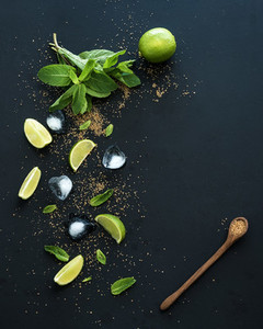 Ingredients for mojito  Fresh mint  limes  ice  sugar over black backdrop  Top view