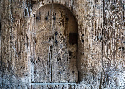 Background of weathered old rustic painted wood with a small door