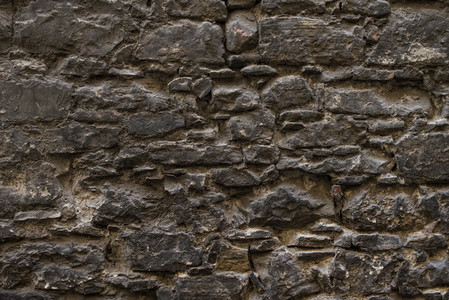 Dark brown old medieval natural stone wall  Texture  background or wallpaper