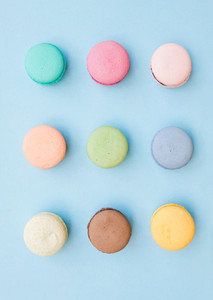 Sweet colorful French macaroon biscuits on pastel blue background