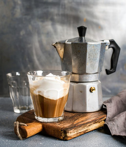 Glass of coffee with ice cream on rustic wooden board and steel Italian Moka pot