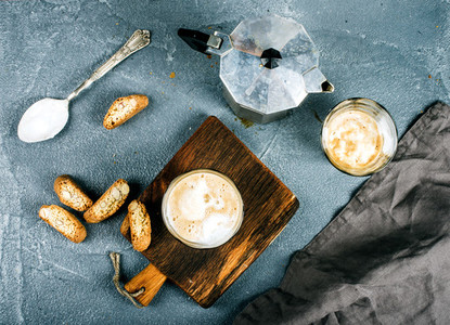 Glasses of coffee with ice cream on rustic wooden board  steel Italian Moka pot over grey concrete textured background