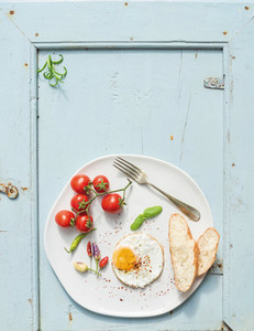 Breakfast set Fried egg bread slices cherry tomatoes hot peppers and herbs