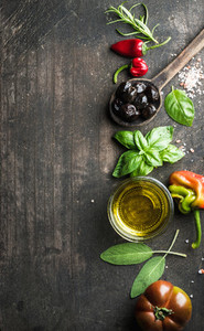 Food background with vegetables  herbs and condiment  Greek black olives  fresh basil  sage  rosemary  tomato  peppers  oil on dark rustic wooden background