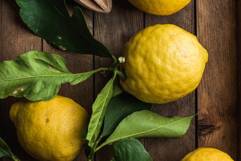 Fresh lemons with leaves in rustic wooden box