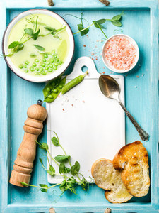 Light summer green pea cream soup in bowl with sprouts  bread toasts and spices  Top view  copy space
