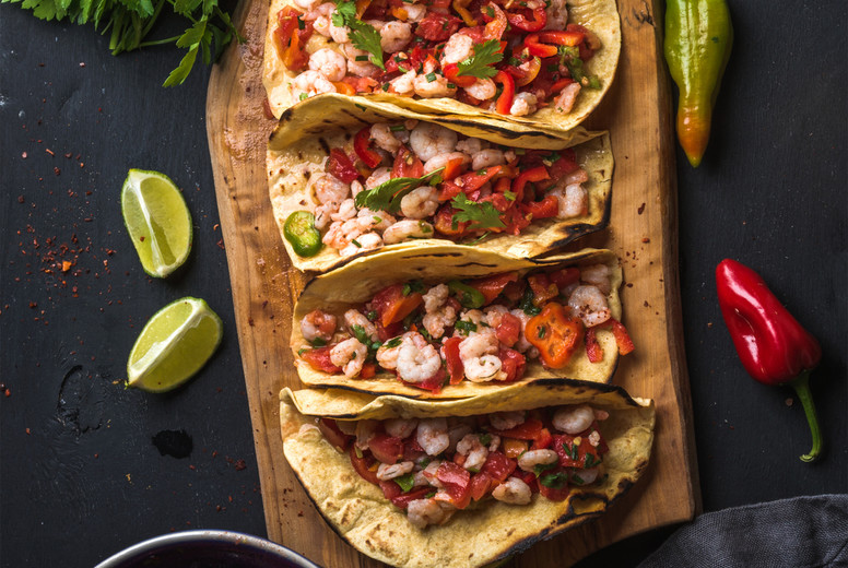 Shrimp tacos with homemade salsa, limes and parsley