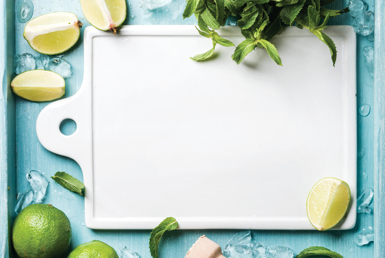 Ingredients for making mojito summer cocktail: chipped ice, mint leaves, brown sugar and lime on turquoise blue painted wooden background