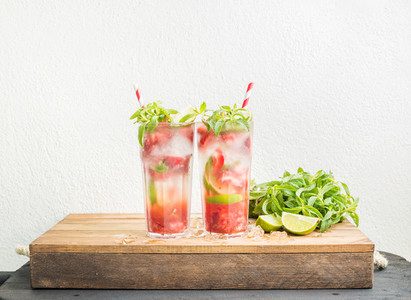 Strawberry mojito summer cocktails with mint and lime in tall glasses
