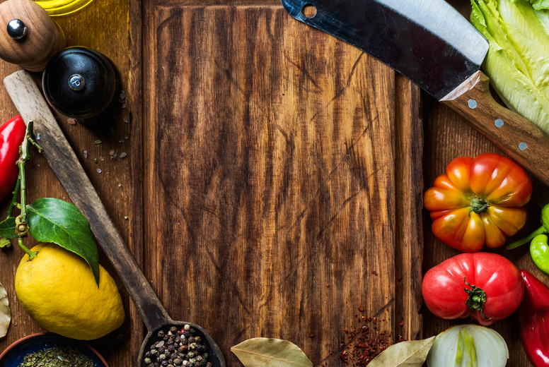 Ingredients for cooking healthy meat dinner. Raw uncooked lamb chops with vegetables, rice, herbs and spices over rustic wooden background, dark chopping board in center