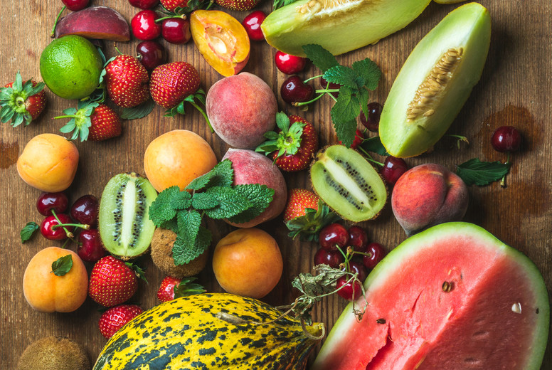 Various colorful tropical fruit selection on rustiv wooden background