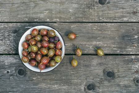 A bawl of gooseberries on a wooden surface