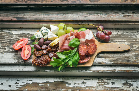 Meat appetizers selection on the old painted wood background