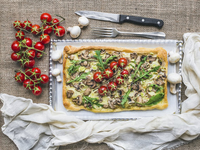 Rustic square mushroom pizza with fresh arugula and cherry tomat