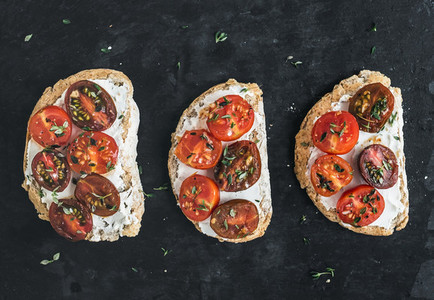 Ricotta and cherry tomato sandwiches with fresh thyme over a dar