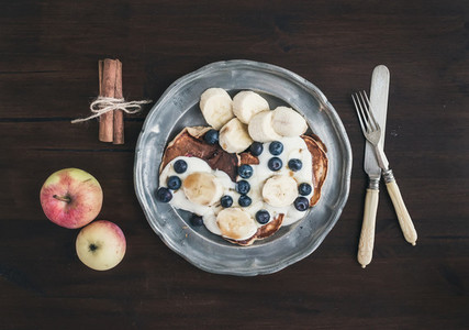 Breakfast set on dark wooden desk apple and cinnamon pancakes w