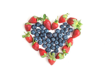 Heart sign made of fresh blueberries and strawberries on a white