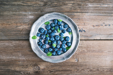 Old vintage metal plate full of fresh ripe blueberries