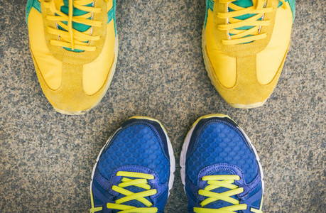 Two pairs of bright sport shoes standing in front of each other