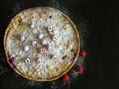 Raspberry and mascarpone pie on a black background