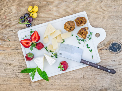Cheese and fruit set on a wooden desk