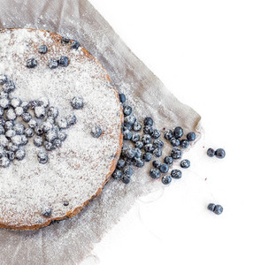 Blueberry cake with fresh bluberries and sugar powder on a beige