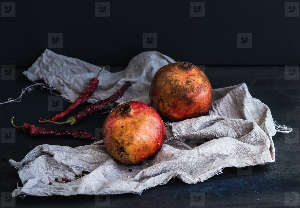 Red ripe pomegranate with spices on dark background