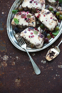 Semifreddo or italian cheese ice cream dessert with garden berries and mint on vintage silver tray over metal rusty grunge background  top view